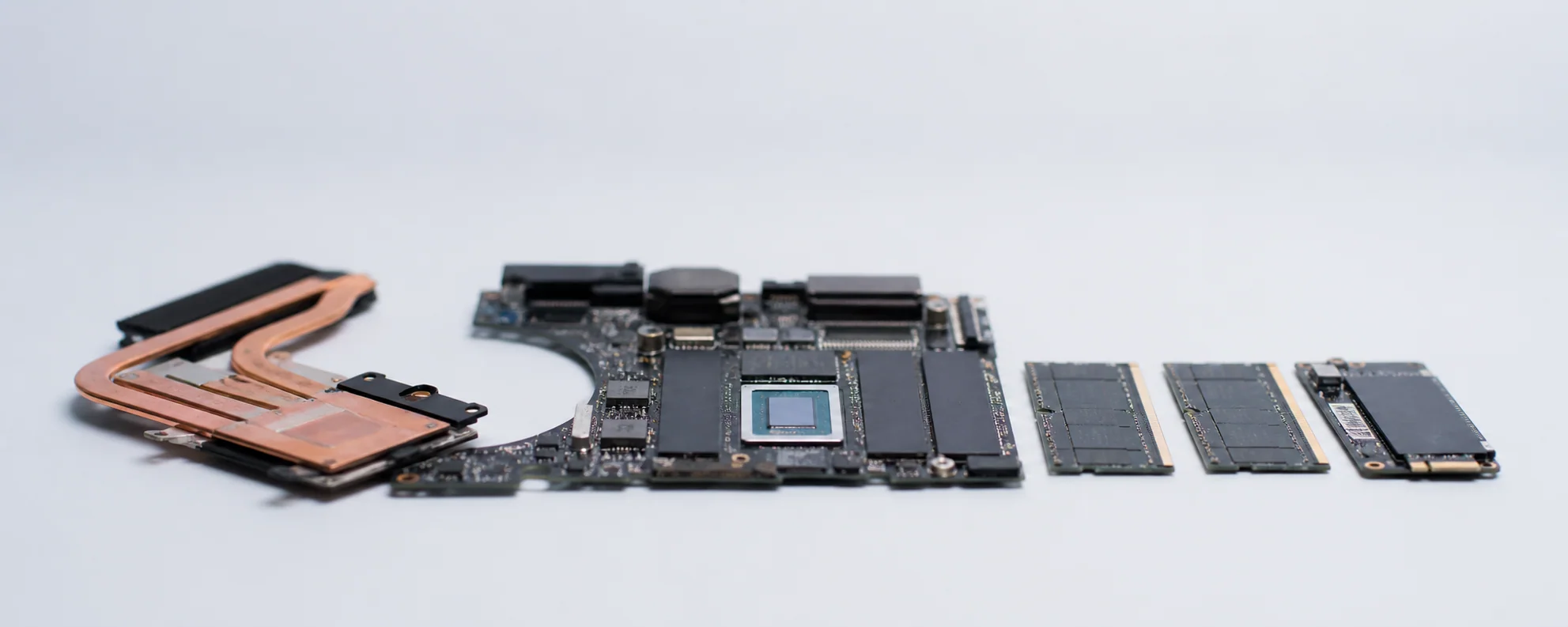 Scheda madre di un portatile con heat pipe, moduli di memoria e un SSD allineati