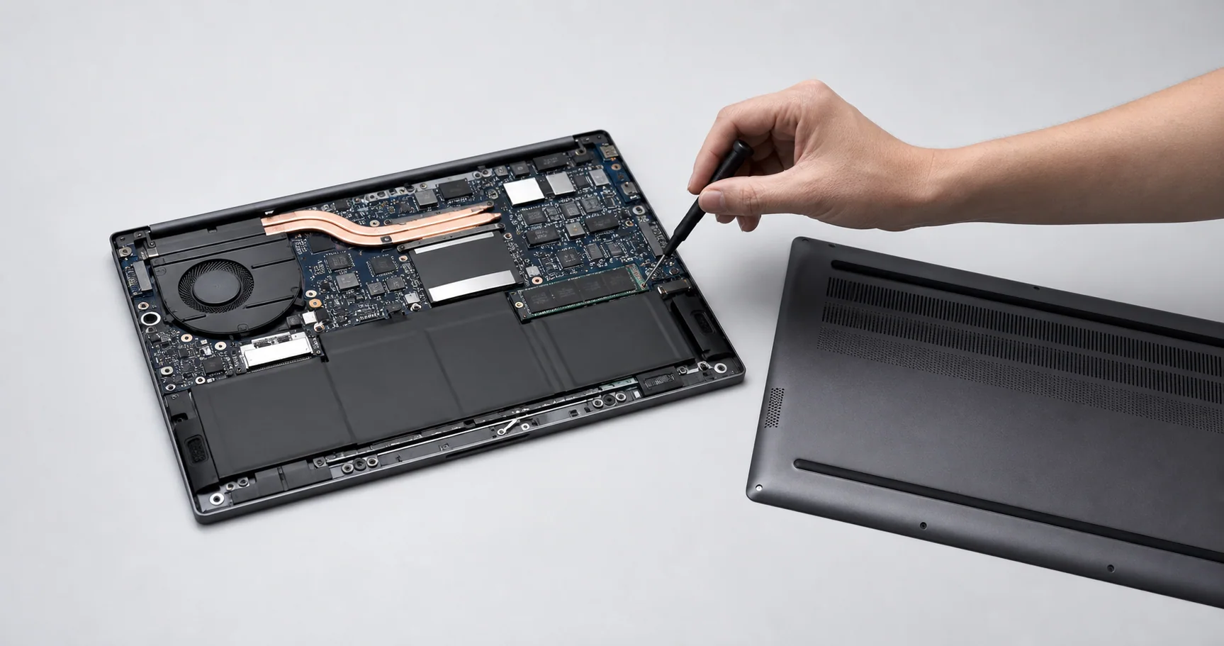 Notebook aperto dal fondo con il pannello inferiore rimosso, heat pipe e SSD in vista
